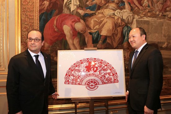 中國僑網陳文雄代表華裔族群向奧朗德總統(tǒng)贈送的富有中國特色的“生肖賀歲”剪紙。(法國《歐洲時報》)