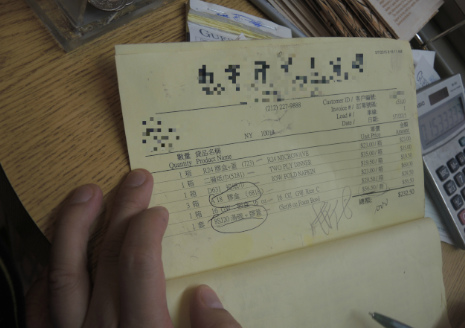 中國僑網(wǎng)餐館業(yè)者展示每月餐具進貨單,塑料餐盒比保麗龍貴至少三倍。(美國《世界日報》/尹英姿 攝)