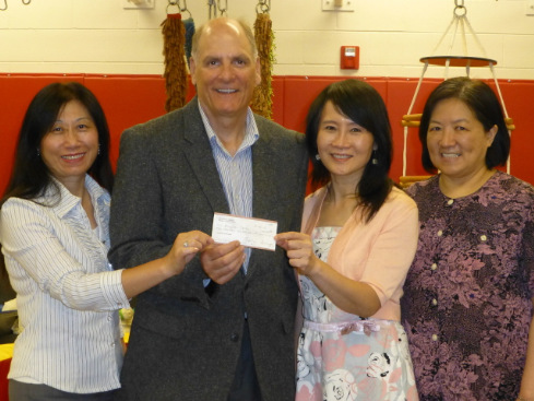 密歇根中華婦女會會長陳淳音（右二）、副會長顏毓萍（左一），代表婦女會捐款盲童中心，由執(zhí)行主任席巴利（左二）代收，右一為財務(wù)汪建華。（美國《世界日報》）