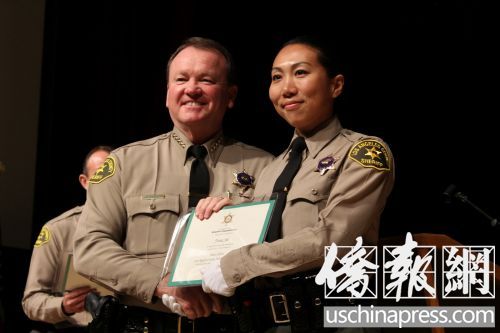 麥唐納局長向石玉娜辦法畢業(yè)證書。(美國《僑報》/高睿