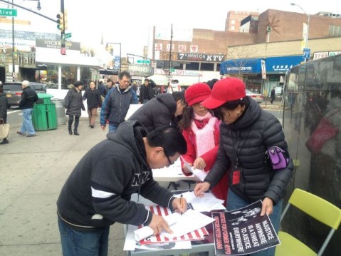 法拉盛街頭每天都有民眾為梁彼得簽請愿書。(讀者提供)