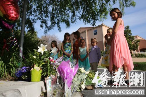 韓偉東5歲女兒艾米麗的同學(xué)及朋友在韓宅不遠(yuǎn)的街道上為韓家獻(xiàn)花,寄托哀思。(美國《僑報》/邱晨