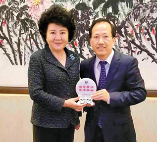 圖為梁冠軍(右)與國(guó)務(wù)院僑辦主任裘援平合影。