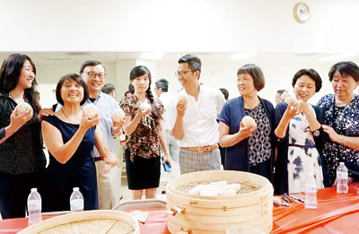 童啟華(中)在劍橋中國文化中心向老師們介紹包子。(美國《星島日報》)