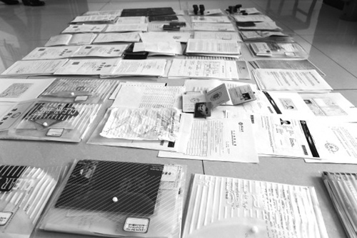 警方在李某辦公間查獲的用于偷渡的假證件、公章等。