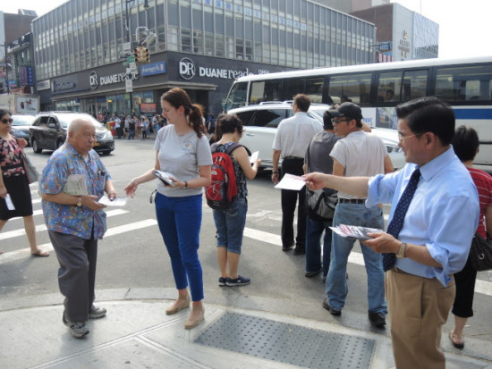 顧雅明、李羅莎等在紐約法拉盛街頭向行人發(fā)放宣導(dǎo)材料。(美國《僑報》/朱蕾