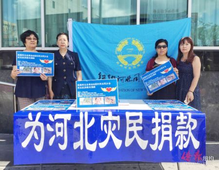 紐約河北同鄉(xiāng)會會長簡平(左二)和義工在法拉盛圖書館前為河北洪水災(zāi)害募捐。