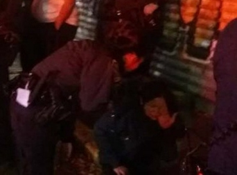 警方在向坐在地上的受害者詢問(wèn)情況。(美國(guó)《世界日?qǐng)?bào)》/讀者提供)