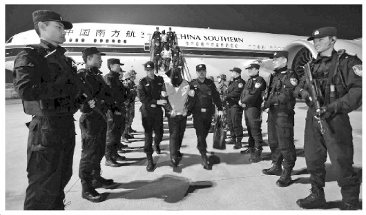 中國僑網(wǎng)圖為警方押解嫌疑人下飛機(jī)。張偉 攝