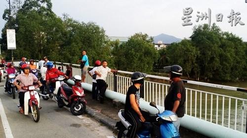 中國僑網(wǎng)一名疑患有憂郁癥的54歲華裔男子企圖跳河自殺事件發(fā)生后,引來大批民眾在峇株巴轄橋一帶圍觀。(馬來西亞《星洲日?qǐng)?bào)》)