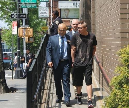 中國僑網(wǎng)賴威爾森(前右)被109分局探員帶往法官過堂。(美國《世界日報》檔案照)