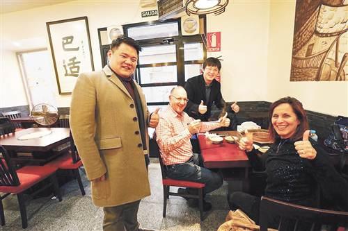 中國僑網(wǎng)萬千百(前左)、何思行(后)與顧客合影。