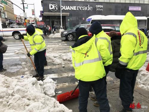 中國僑網(wǎng)法拉盛商改區(qū)工作人員認(rèn)真鏟雪。(美國《僑報》/王伊琳 攝)