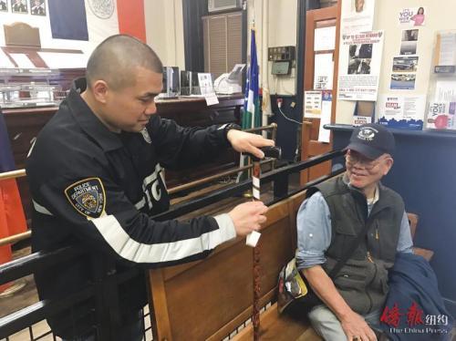 中國(guó)僑網(wǎng)五分局警員為耆老的拐杖貼上安全反光貼。(美國(guó)《僑報(bào)》)