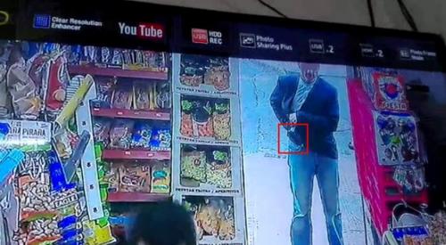 中國僑網(wǎng)圖為當(dāng)時該名歹徒在謝先生店門口準(zhǔn)備掏槍進(jìn)行威脅。(西班牙歐浪網(wǎng)/華人店主提供)