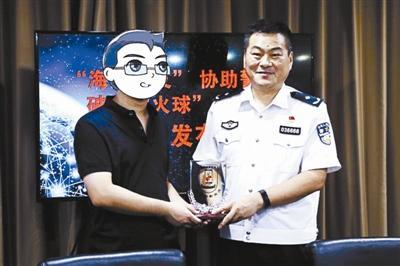 中國僑網(wǎng)海淀公安分局副局長趙磊砢給網(wǎng)友頒發(fā)杰出網(wǎng)友獎杯