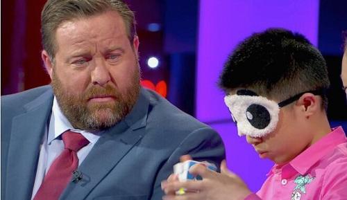 中國僑網(wǎng)資料圖:闕劍宇蒙眼復(fù)原魔方(圖片來源于《南華早報(bào)》)