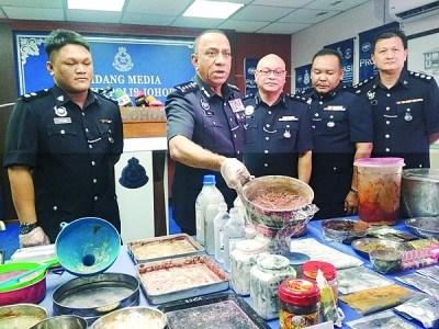 中國僑網(wǎng)莫哈末卡利(左2)展示行動(dòng)中起獲的毒品粉末。(馬來西亞《光華日?qǐng)?bào)》)