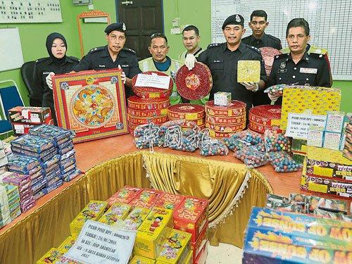 中國僑網(wǎng)莫哈末阿里(前排右2)展示起獲的煙花和爆竹。(馬來西亞《中國報》)
