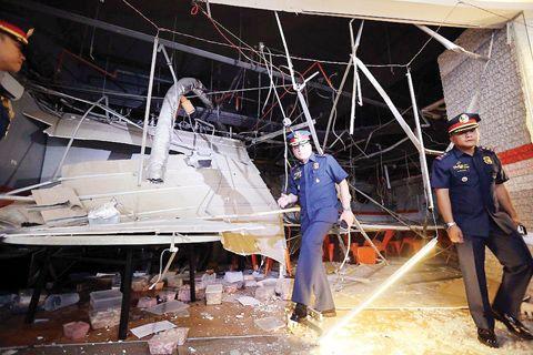 中國僑網(wǎng)菲律賓計順市警區(qū)警長伊利薩和消防局人員昨日(5日)檢查計順市萬納威區(qū)一間因煤氣爆炸而著火的餐館。一名香港人在事件中受傷送院。(《菲律賓商報》)