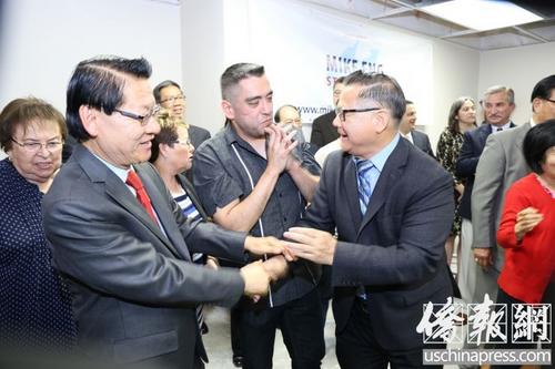 中國僑網(wǎng)美國圣蓋博市議員廖欽和(右)向伍國慶表示祝賀。(美國《僑報》/高睿 攝)