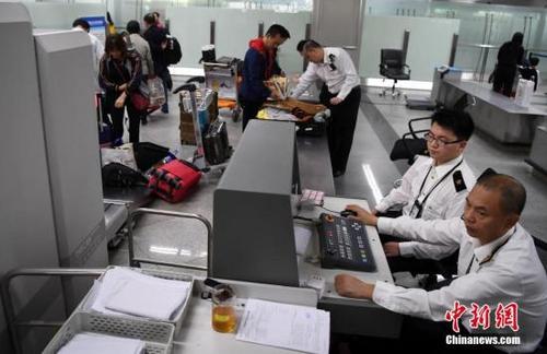 中國僑網(wǎng)資料圖:圖為福州海關(guān)隸屬長樂機(jī)場海關(guān)關(guān)員對入境旅客實(shí)施過機(jī)查驗(yàn)。 中新社記者 張斌 攝
