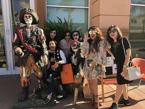 中國(guó)僑網(wǎng)美國(guó)洛杉磯一群華裔女士站在凱旋宮骷髏周圍裝出“怕怕”的樣子。(美國(guó)《僑報(bào)》/高睿 攝)