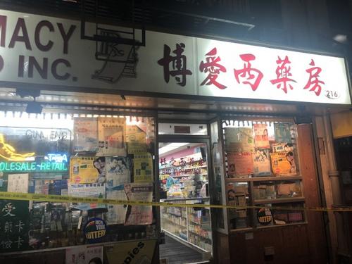 中國僑網(wǎng)案發(fā)的紐約華埠博愛西藥房門前拉上了警戒線。(美國《世界日報》/張晨 攝)