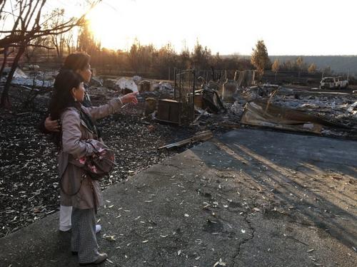 中國僑網(wǎng)于燕玲站在廢墟之前,感慨萬千。(美國《世界日?qǐng)?bào)》/李晗 攝)