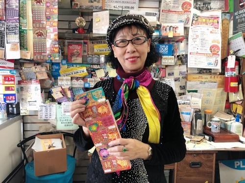 中國僑網美國加州蒙特利公園市彩券業(yè)者古小姐介紹豬年刮刮樂。(美國《世界日報》/張宏 攝)