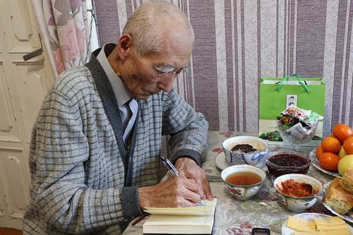 中國僑網(wǎng)圖為耄耋之年的郭貴義在用漢語寫他的名字。(吉爾吉斯斯坦《絲路新觀察》)