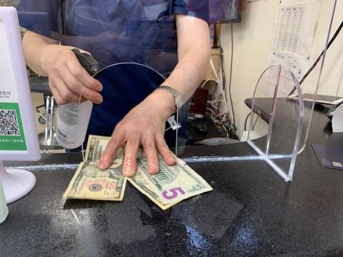 中國(guó)僑網(wǎng)美國(guó)華人理發(fā)業(yè)者進(jìn)行清潔與消毒,找客人錢之前會(huì)噴酒精消毒。(美國(guó)《世界日?qǐng)?bào)》/賴蕙榆 攝)