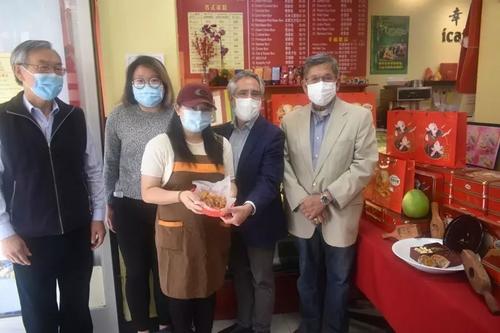 中國(guó)僑網(wǎng)幸福餅家東主張曉燕(中)與參加記者會(huì)的人士分享新鮮出爐的月餅。(美國(guó)《世界日?qǐng)?bào)》/黃少華 攝)