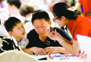 中國僑網(wǎng)不少家長帶著孩子前來選擇暑期旅游產(chǎn)品。(廣州日報/莊小龍 攝)