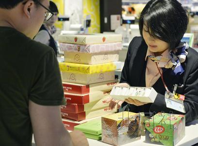 成田機場免稅店內(nèi)一名店員正在應對外國游客購物。(共同社)