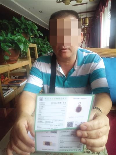 中國僑網(wǎng)薛先生向記者展示紅寶石的鑒定書