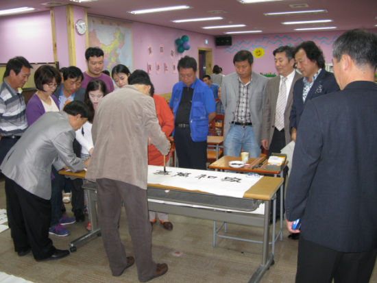 中國僑網(wǎng)向現(xiàn)場嘉賓展示書法技藝