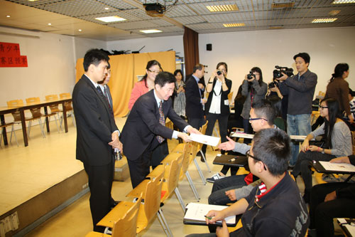 中國僑網(wǎng)雷振剛為參加大賽的學(xué)生發(fā)放試卷。(法國《歐洲時(shí)報(bào)》/黃冠杰 攝)