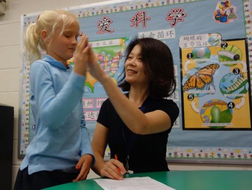 中國(guó)僑網(wǎng)老師正在對(duì)學(xué)生進(jìn)行指導(dǎo)。(美國(guó)僑報(bào)網(wǎng)援引《紐約時(shí)報(bào)》)