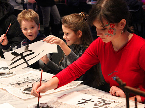 中國僑網(wǎng)孩子們興奮地相互欣賞自己的書法作品