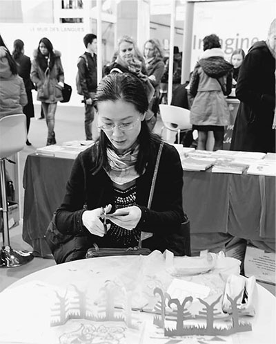 中國僑網(wǎng)法國克萊蒙費朗孔子學院的老師在展示剪紙藝術。記者 王遠 攝