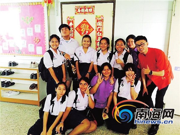 中國僑網(wǎng)春節(jié)期間,志愿者閆海(右一)跟學(xué)生一起貼完春聯(lián)后合影。