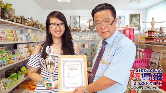 匈牙利東方國藥集團(tuán)董事長(zhǎng)陳震博士（右）為楊可欣（左）頒發(fā)榮譽(yù)證書。（匈牙利《新導(dǎo)報(bào)》）