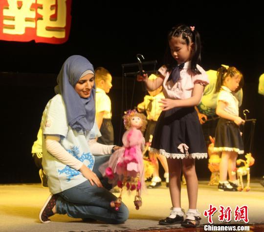 圖為泉州小朋友細(xì)心教授選手提線(xiàn)木偶。　廖靜　攝