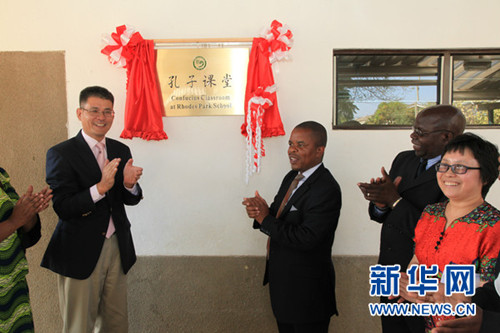 贊比亞教育部副部長悉尼·穆杉戛(中)和中國駐贊比亞大使楊優(yōu)明(左一)為孔子課堂揭牌。