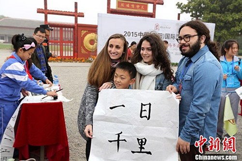 一名一年級小學生將自己書寫的書法作品“一日千里”贈與法國朋友。