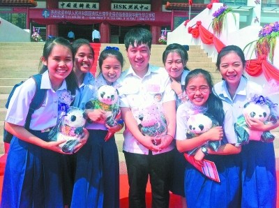 李文龍(中)和他的泰國學(xué)生合影(資料照片)。