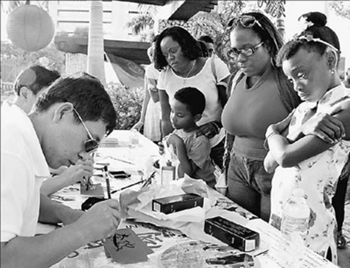 在巴巴多斯首都布里奇敦的“魚(yú)龍節(jié)”上,民眾排隊(duì)等待自己名字的“中文版”