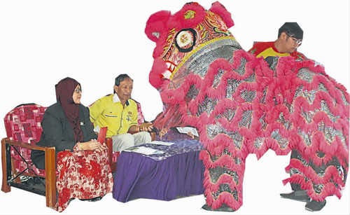 校長(zhǎng)娜哈瑪與家協(xié)主席沙立夫與醒獅互動(dòng)并遞上年柑。