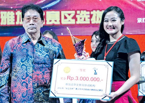 雅加達(dá)華文教育協(xié)調(diào)機(jī)構(gòu)輔導(dǎo)委員會(huì)常務(wù)主席楊健強(qiáng)(左)為一等獎(jiǎng)獲得者方馨楦(右)頒獎(jiǎng)